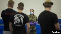 FILE - Lt. Cmdr. Jennifer Knapp with 3rd Medical Battalion, 3rd Marine Logistics Group, briefs U.S. Navy sailors assigned to the aircraft carrier USS Theodore Roosevelt on coronavirus disease quarantine procedures at Naval Base Guam, April 8, 2020.