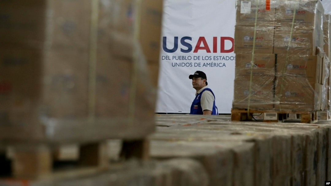 Foto Achiv: Yon neg pase bo kote bwat kes asistans imanite USAID nan yon depo nan Cucuta, Kolonbi, 21 Fevriye 2025.
