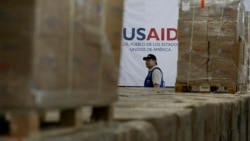 Seorang pria berjalan di antara kardus-kardus berisi bantuan kemanusiaan dari USAID di sebuah gudang di Jembatan Internasional Tieditas di pinggiran Cucuta, Kolombia, pada 21 Februari 2019. (Foto: AP/Fernando Vergara)