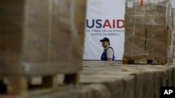 Seorang pria berjalan di antara kardus-kardus berisi bantuan kemanusiaan dari USAID di sebuah gudang di Jembatan Internasional Tieditas di pinggiran Cucuta, Kolombia, pada 21 Februari 2019. (Foto: AP/Fernando Vergara)