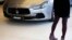 FILE - A woman looks at a Maserati Ghibli car at its dealership in Seoul, March 2, 2015.