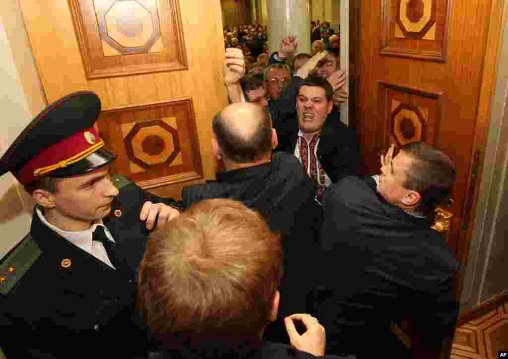 Opposition lawmakers chase away two colleagues from the parliament hall, Kyiv, Ukraine, December 12, 2012.