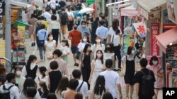 Para pejalan kaki mengenakan masker saat mengunjungi kawasan Takeshita di Tokyo, di tengah pandemi COVID-19, Rabu, 28 Juli 2021. (AP)