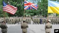 Polish Army soldiers hold flags of some of the countries participating in the Anakonda-16 military exercise, during the opening ceremony, in Warsaw, Poland on June 6, 2016. 