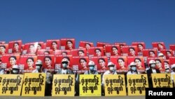 Demonstrators hold placards with the image of Aung San Suu Kyi during a protest against the military coup, in Naypyitaw, Myanmar, Feb. 15, 2021.