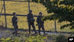 South Korean army soldiers patrol the wire fences near the demilitarized zone between the two Koreas in Paju, South Korea, Oct. 7, 2014.