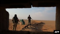 FILE - Iraqi Shi'ite fighters secure the border area with Syria in Al Qaim in Iraq's Anbar province, Nov. 12, 2018.