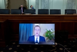FILE - Facebook CEO Mark Zuckerberg appears on a screen as he speaks remotely during a hearing before the Senate Commerce Committee on Capitol Hill, Oct. 28, 2020.