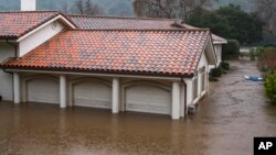 A garage is flooded by the overflowing Carmel River on Paso Hondo Road in Carmel Valley, California, Jan. 9, 2023.