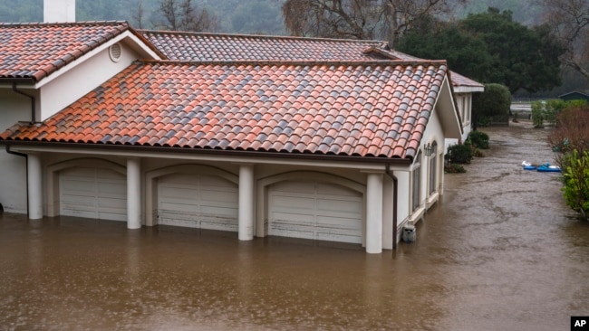 A garage is flooded by the overflowing Carmel River on Paso Hondo Road in Carmel Valley, California, Jan. 9, 2023.
