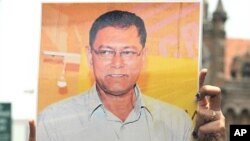 A journalist holds a photograph of slain newspaper crime reporter Jyotirmoy Dey during a protest rally in Mumbai on June 13, 2011.