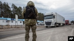 Một sĩ quan biên phòng Ukraine canh gác tại trạm kiểm soát biên giới với Belarus ở Novi Yarylovychi, ngày 21/2/2022. Belarus cáo buộc Ukraine đang triển khai quân dọc biên giới 2 nước.