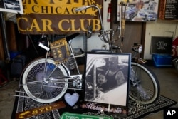 Foto bayi Daniel Marquez, (kini berusia delapan tahun), sedang duduk di pangkuan mendiang ayahnya Alberto di dalam mobil lowrider Chevy Impala tahun 1963 milik mereka, dipajang bersama sepeda lowrider krom kustom yang dibuat Daniel di rumahnya di Frankfort, Ill. (Erin Hooley/AP)