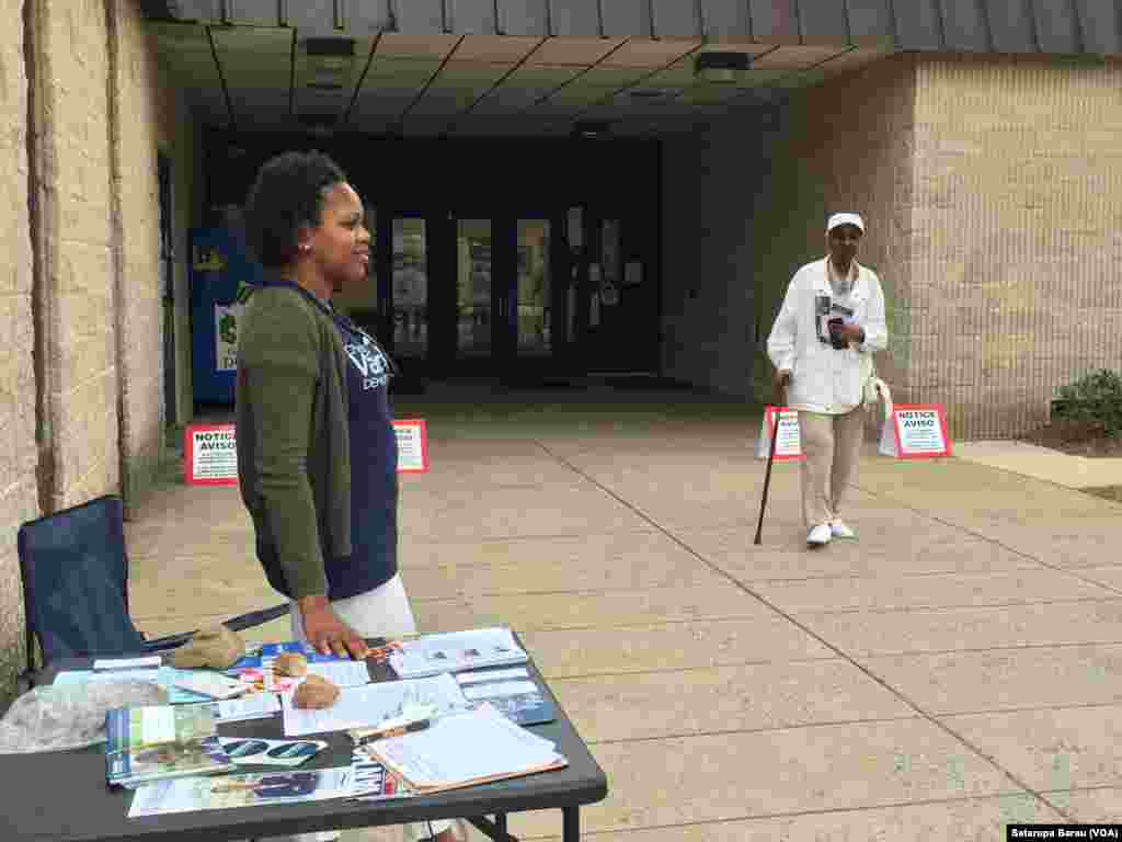 A volunteer with the African-American Democratic Club of Montgomery County, Maryland, is ready to hand out information on local politicians as voters approach the polling station at Watkins Mill Elementary School in Montgomery Village, April 26, 2016. 