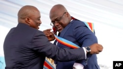 Président Joseph Kabila, mokonzi oyo atiki ngwende apesi bilembo ya bonkonzi na Félix Tshisekedi mokitani na ye na libonga ya président ya république, na milulu masalemi na etando ya Palais ya nation, na Kinshasa, le 24 janvier 2018. 