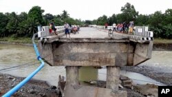 Warga berkumpul di jembatan yang dirusak oleh banjir yang disebabkan oleh badai tropis Tembin, 24 Desember 2017, di Zamboanga Del Sur di Filipina selatan.