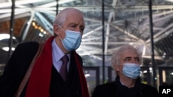 Lawyers George Henri Beauthier, left, and William Bourdon, right, representing the National Council of Resistance of Iran, speak with the media as they arrive at the courthouse in Antwerp, Belgium, Nov. 27, 2020.