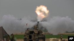 FILE — An Israeli mobile artillery unit fires a shell from southern Israel towards the Gaza Strip, in a position near the Israel-Gaza border on Sunday, Dec. 10, 2023.