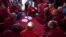 Activist known as Ko Kyaw, left background in blue pants, gestures during a meeting with protesting Buddhist monks who occupy the office entrance to the Chinese copper mine company Wan Bao Co. Ltd in northwestern Myanmar, Wednesday, Nov 28, 2012.