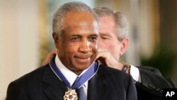 El expresidente George W. Bush coloca a Frank Robinson la Medalla Presidencial de la Libertad en el Salón Este de la Casa Blanca en Washington, el 9 de noviembre de 2005. Robinson falleció el jueves 7 de febrero de 2019.