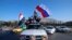 FILE - Syrian government supporters wave Syrian, Iranian and Russian flags during demonstrations following April 2018 military strikes by U.S., British and French forces in Syria. Russia and Iran are allies of Syrian President Bashar al-Assad.
