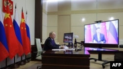 En esta fotografía distribuida por la agencia estatal rusa Sputnik, el presidente de Rusia, Vladimir Putin, mantiene una videollamada con el presidente chino, Xi Jinping, en la residencia estatal Novo-Ogaryovo, en las afueras de Moscú, el 21 de enero de 2025. 