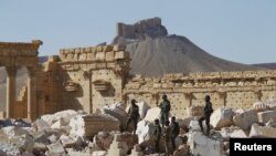 Binh sĩ quân đội Syria đứng trên đống đổ nát của ngôi đền Bel tại thành cổ Palmyra, ở Homs, Syria, ngày 01 tháng 4 năm 2016. 