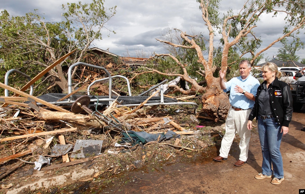 John Doak, left, Oklahoma Insurance Commissioner, and Oklahoma Gov. Mary Fallin, center, tour a tornado damaged home in Woodward, Oklahoma April 15, 2012. (AP Photo)