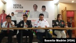 Direktur Hukum dan Advokasi Tim Kampanye Nasional (TKN) Jokowi-Ma'ruf, Ade Irfan Pulungan (jaket putih) bersama timnya saat menggelar konferensi pers di Posko Cemara di Jakarta, Selasa (26/3/2019) (foto: VOA/Sasmito Madrim)