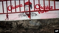 A man walks in front of a mural of Venezuela's late President Hugo Chavez in Caracas, Venezuela, March 4, 2014. 