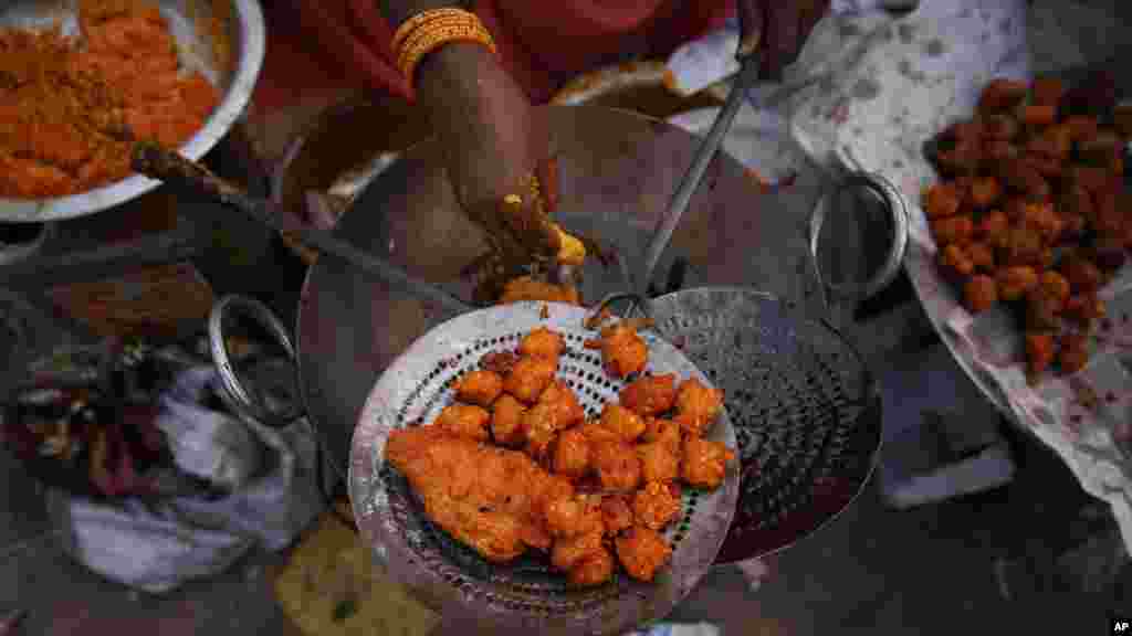 Une femme vend des baignets qu&#39;elle prépare avec ses mains. Des maladies contagieuses peuvent être évitées avec le lavage regulier des mains. (AP Photo/Saurabh Das) 