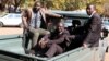 Douglas Mahiya, information secretary of the Zimbabwe National Liberation War Veterans Association (ZNLWVA) is escorted by detectives as he arrives at the Harare Magistrates' court, July 29, 2016. Mahiya was detained on Wednesday over a statement the association issued last week attacking President Robert Mugabe's rule. REUTERS/Philimon Bulawayo - RTSKA28