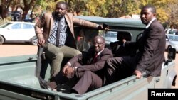 Douglas Mahiya, information secretary of the Zimbabwe National Liberation War Veterans Association (ZNLWVA) is escorted by detectives as he arrives at the Harare Magistrates' court, July 29, 2016. Mahiya was detained on Wednesday over a statement the association issued last week attacking President Robert Mugabe's rule. REUTERS/Philimon Bulawayo - RTSKA28