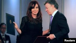 Los presidentes de Argentina, Cristina Fernández, y de Colombia, Juan Manuel Santos, intercambian copias de los acuerdos.
