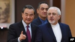 Iranian Foreign Minister Mohammad Javad Zarif (R) arrives with Chinese Foreign Minister Wang Yi for a joint press conference in Beijing, China, Dec. 5, 2016. Zarif said that nations party to the Iran nuclear deal "have the obligation to fully implement it