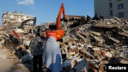 La gente mira los escombros y los escombros tras un terremoto en Kahramanmaras, Turquía, el 8 de febrero de 2023. REUTERS/Suhaib Salem