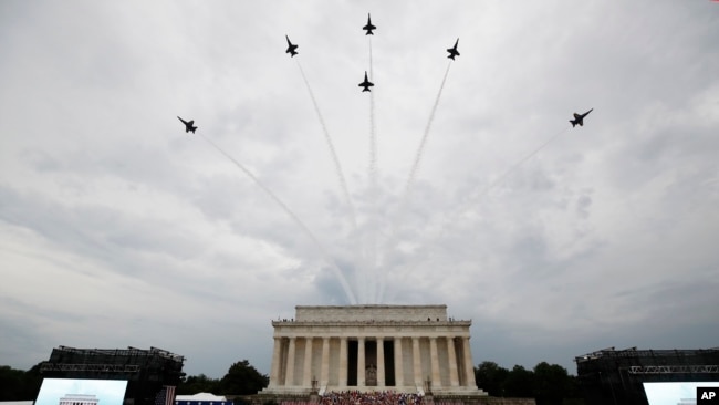 美国海军蓝天使特技飞行队的飞机飞过林肯纪念堂的上空，特朗普总统和第一夫人梅拉妮亚、副总统彭斯等人站立观看，美国陆军乐队演奏。(2019年7月4日)
