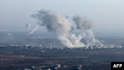 In this picture taken from the northern Syrian village of Ariha, smoke billows from the site of clashes and mutual shelling on the outskirts of the city of Saraqib in Syria's Aleppo province on Nov. 28, 2024. 