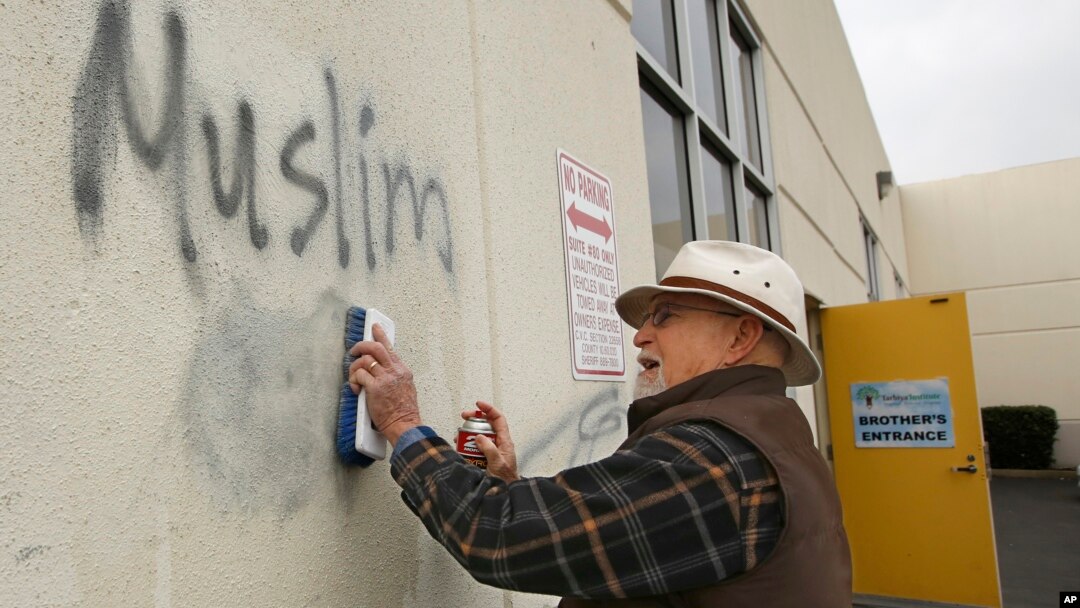 Mahalliy fuqarolardan biri masjid devoriga yozib ketilgan yozuvni o'chirmoqda, Rouzvil, Kaliforniya, 2017-yil, 1-fevral.