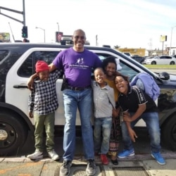 Sergeant Keith Mott poses for a photo with a mentee and the child's siblings during a Big Brother Big Sisters of America activity.