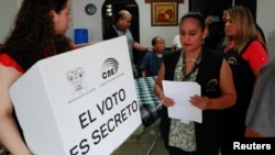 Funcionarios del Consejo Nacional Electoral de Ecuador asisten a personas discapacitadas durante una jornada de voto anticipado, en Guayaquil, el 7 de febrero de 2025. Este domingo 9 de febrero de 2025 Ecuador celebra elecciones presidenciales.