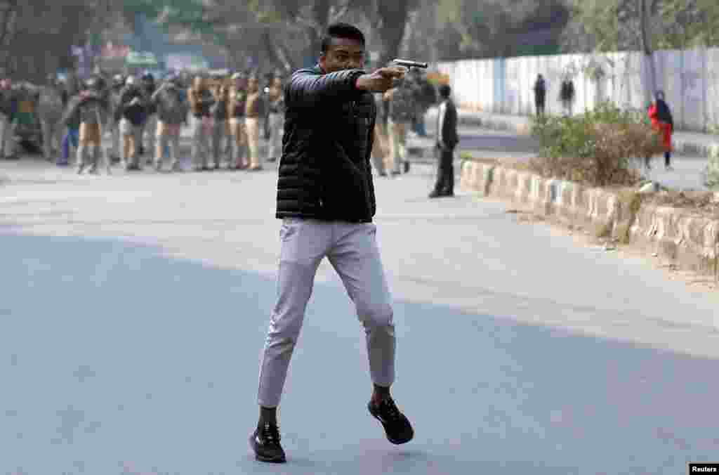 An unidentified man brandishes a gun during a protest against a new citizenship law outside the Jamia Millia Islamia university in New Delhi, India.
