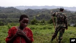 FILE - A Congolese girl walks past a Uruguayan United Nations peacekeeper.