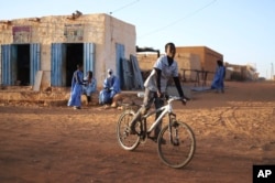 Un niño monta su bicicleta en Chinguetti, Mauritania, 4 de febrero de 2025.