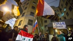 Manifestantes protestan con banderas rusas y sirias frente a la Embajada de Turquía en Moscú, en respuesta al derribamiento de un avión militar ruso por parte de Turquía el martes 24 de noviembre de 2015.