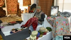 A Kashmiri shawl seller displays newly handmade Pashminas at Kashmir Handicrafts Exhibition in Srinagar, Indian-administered Kashmir, on Nov. 27, 2024. (Wasim Nabi for VOA)