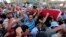 Supporters of deposed Egyptian President Mohamed Morsi carry mock coffins during a symbolic funeral for the four men killed during clashes with police outside the Republican Guard headquarters a day earlier, in Cairo, July 6, 2013. 