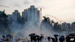 Manifestan ki t ap lanse bwat gaz lakrimojèn sou lapolis nan Hong Kong nan jounen lendi 5 out 2019 la. (Foto AP/Kin Cheung). 