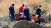 A crew carries what are believed to be remains of a 6-year-old girl, near Xiliatos, Cyprus, June 12, 2019. The remains are thought to be those of a victim of a confessed serial killer, a 35-year-old Cyprus army captain.