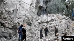 Les gens inspectent un site endommagé après des frappes aériennes sur le quartier Tariq al-Bab tenu par les rebelles, à Alep, Syrie, 23 septembre 2016. 